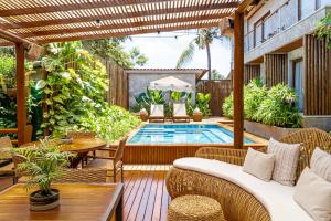 an outdoor patio with a pool and tables and chairs at Vila Sal Boutique Noronha in Fernando de Noronha