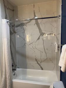 a bathroom with a shower and a white tub at Spark by Hilton Opelousas in Opelousas