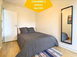 sypialnia z łóżkiem i dużym lustrem w obiekcie Idéal Groupe - Grands Espaces - 4 chambres - Parking Gratuit - Proche Centre, Gare & Transports - Wifi - OFFRE SPECIAL de Reduction jusqu'à -50 w mieście Le Mans