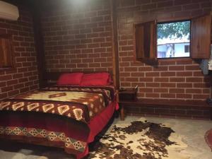 a bedroom with a bed in a brick wall at Casa playa Manglaralto in Manglaralto
