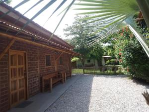 a brick house with a wooden door and a bench at Casa playa Manglaralto in Manglaralto
