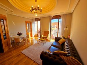 a living room with a leather couch and a table at Suite Legio VII in León