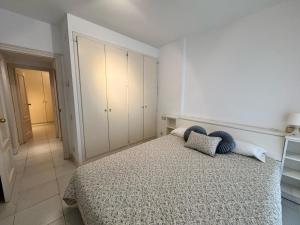 una camera da letto con un letto con due cuscini sopra di Apartamento a 100 metros de la playa con aire acon a Tossa de Mar