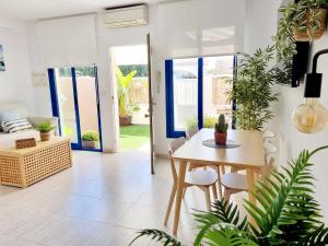 a living room with a table and chairs and plants at Adosadito Playa Oliva in Oliva