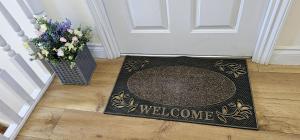a welcome mat in front of a door with a welcome sign at Apartment Ivy - Part of the The Bay Filey Holiday Village with pool, gym and direct beach access, pub, restaurant, tennis and meadows walks in Filey