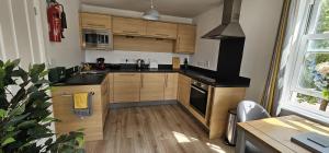 a kitchen with wooden cabinets and a sink and a stove at Apartment Ivy - Part of the The Bay Filey Holiday Village with pool, gym and direct beach access, pub, restaurant, tennis and meadows walks in Filey
