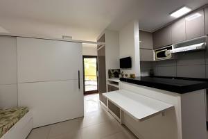a kitchen with white cabinets and a white counter top at Jubiabá - 214C - Vista Mar in Ilhéus