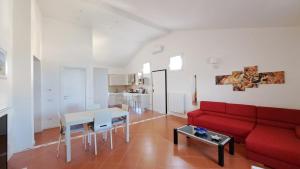 a living room with a red couch and a table at Mamma Wanda Sea View Home Amalfi Coast in Vietri sul Mare