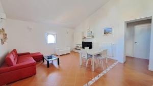 a living room with a red couch and a table at Mamma Wanda Sea View Home Amalfi Coast in Vietri sul Mare