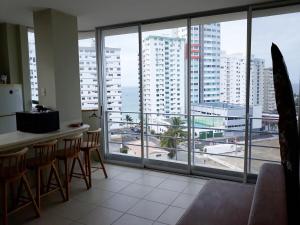 a kitchen with a view of a city from a large window at Acogedora suite en la playa in Salinas