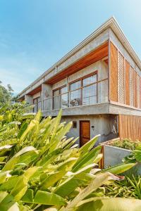 une maison avec une bande de plantes devant elle dans l'établissement Vila Sal Boutique Noronha, à Fernando de Noronha