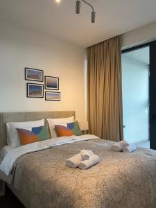 a bedroom with a bed with two towels on it at Forest View Apartment in Rogača