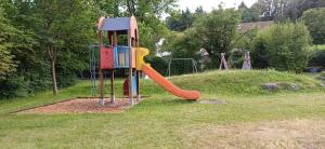 a playground with a slide in a park at Gutheils-Ferienwohnung in Nanzdietschweiler