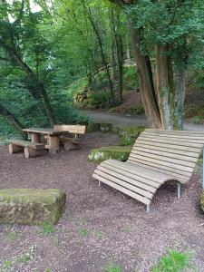 a wooden bench and a picnic table in a park at Gutheils-Ferienwohnung in Nanzdietschweiler