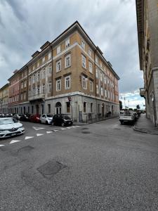 a large brick building with cars parked in a parking lot at Da NOI A TRIESTE in Trieste