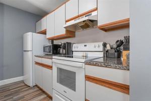 a kitchen with white appliances and a white refrigerator at The Village at Paugus Bay Condo! in Laconia