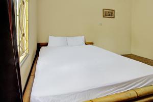 a white bed in a room with a window at Hotel O Zahira Homestay Near Ekas Surf School and Service in Ekas +18 photos