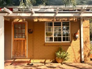 a brick house with a door and a window at Farm stay at Thyme Cottage on Haldon Estate in Bloemfontein