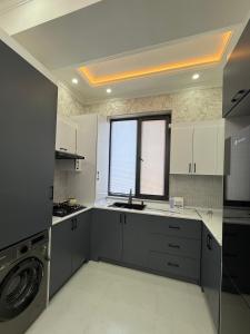 een keuken met een spoelbak en een wasmachine bij Аpartment in Samarkand +21 foto's
