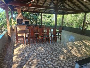 a patio with a table and chairs and a fireplace at Refúgio GRUPOS com piscina, churrasqueiras 38 min Águas Claras Brasília in Brasília