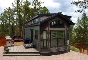 a tiny house sitting on a wooden deck at Moonlight Bungalow in Hill City