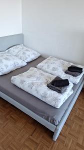 two beds with white sheets and black towels on them at Business Messe Apartment & Wellness Spa in Düsseldorf