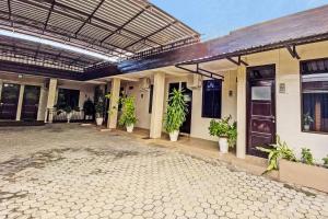 un bâtiment avec un patio avec des plantes dans l'établissement Hotel O Mariko's House, à Kupang
