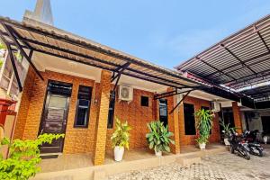 un bâtiment en briques avec des plantes devant lui dans l'établissement Hotel O Mariko's House, à Kupang