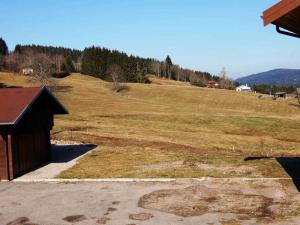 a large grassy hill with a building in the foreground at Chalet des FURETS in Xonrupt-Longemer