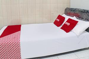 - un lit blanc avec 2 oreillers rouges dans l'établissement Hotel O Mariko's House, à Kupang 24 autres photos