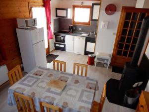 a kitchen with a table with chairs and a refrigerator at Chalet des FURETS in Xonrupt-Longemer +2 photos