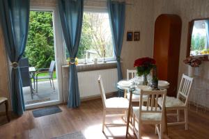 a dining room with a table and chairs and a window at Apartment Miesmuschelparadies in Lübeck