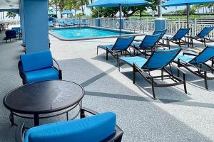 a group of chairs and tables next to a pool at Solara Surfside in Miami Beach