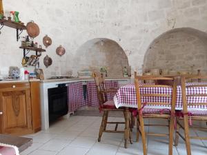 a kitchen with a table and chairs in a room at Trulli Sarmenzanello in Noci +61 photos