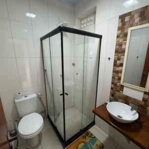 a bathroom with a shower and a toilet and a sink at Viva sol hospedagem in Cabo Frio