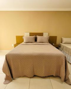 a bedroom with a large bed with a brown blanket at Pousada DOliver in Paraty +27 photos