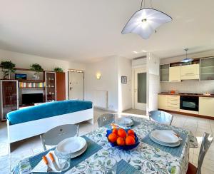a living room with a table and a blue couch at Maison Peschiera in Sirolo