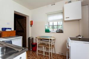 a kitchen with a sink and a table in it at BroomfieldBarns1A in Swettenham