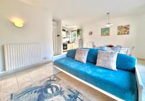 a blue couch in a room with a kitchen at Maison Peschiera in Sirolo