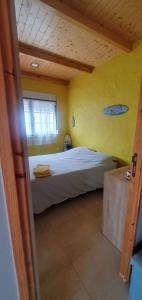 a bedroom with a bed in a yellow wall at Casa Llogan 4P Quinta das Pedras da Lagoa in Alcobaça