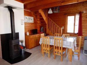 a dining room with a table and a wood stove at Chalet des FURETS in Xonrupt-Longemer