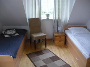 une chambre avec un lit, une chaise et une fenêtre dans l'établissement Modernisierte Ferienwohnung Mit Balkon, à Schuby 31 autres photos