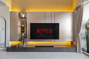 a television on a wall with a netflix sign on it at Bella Elite Homes at Grande Signature Amazing Burj and Fountain View-Brand New Luxury Apartment in Dubai