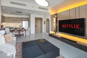 a living room with a netflix sign on the wall at Bella Elite Homes at Grande Signature Amazing Burj and Fountain View-Brand New Luxury Apartment in Dubai