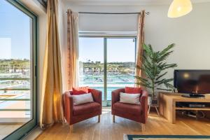Μια τηλεόραση ή/και κέντρο ψυχαγωγίας στο Marina Breeze Apartment with Pool - 900m from the Beach