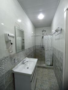 a white bathroom with a sink and a shower at Shaxlo&Ali Hotels in Samarkand