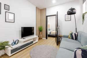 a living room with a tv and a blue couch at Cosy appartement met tuin in centrum Antwerpen Gratis parking Free Parking! in Antwerp