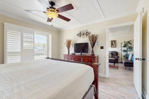 a bedroom with a bed and a ceiling fan at Palm Tree Escape in South Padre Island