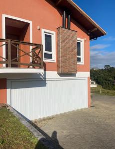 a shadow of a person standing in front of a house at Casa em condomínio rural in Rancho Queimado
