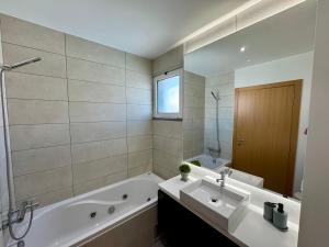 a bathroom with a tub and a sink and a bath tub at Welcome to Paradise Island in Caniço +60 photos